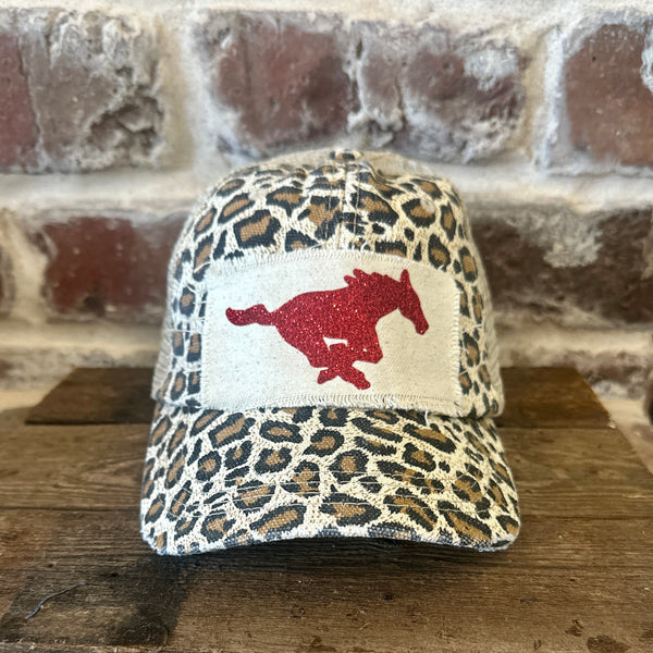 Mustang Pony Glitter Hat by BohoGroove with a red glitter running pony on a distressed off-white patch on a leopard vintage distressed snapback trucker hat.