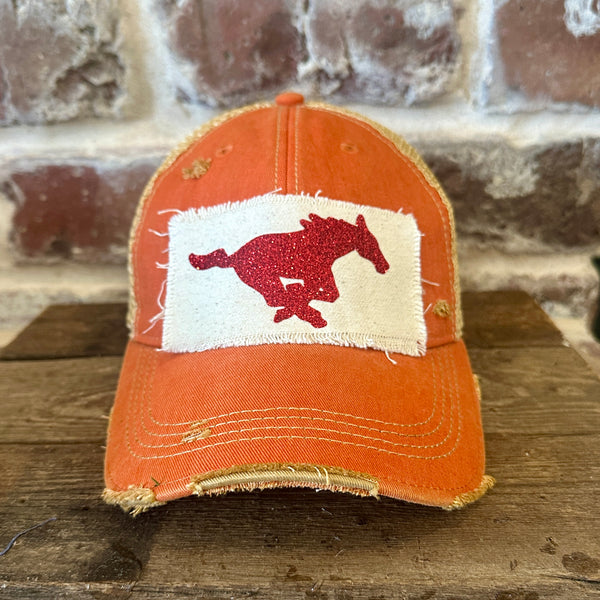 Mustang Pony Glitter Hat by BohoGroove with a red glitter running pony on a distressed off-white patch on an orange vintage distressed snapback trucker hat.