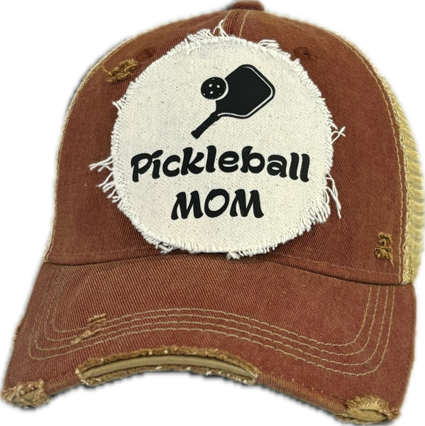 Pickleball Mom hat by BohoGroove featuring black Pickleball Mom lettering and black pickleball paddle graphic on a brick red vintage distressed snapback hat