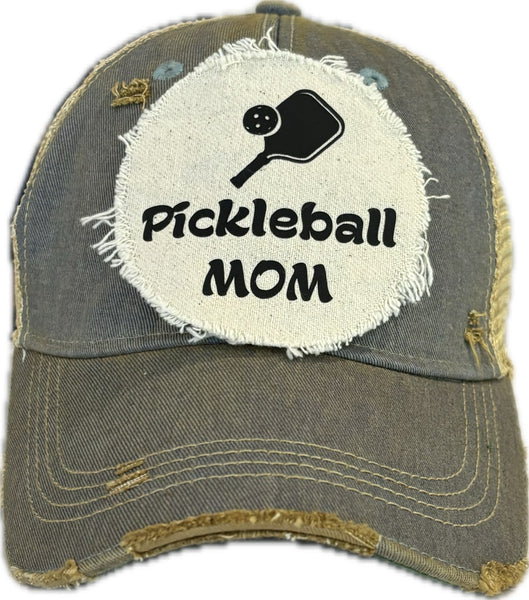 Pickleball Mom hat by BohoGroove featuring black Pickleball Mom lettering and black pickleball paddle graphic on a light blue vintage distressed snapback hat