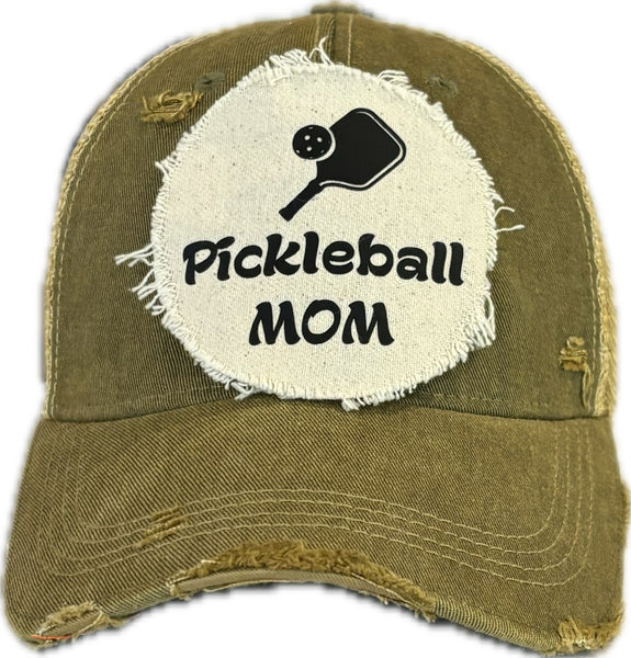 Pickleball Mom hat by BohoGroove featuring black Pickleball Mom lettering and black pickleball paddle graphic on an olive vintage distressed snapback hat