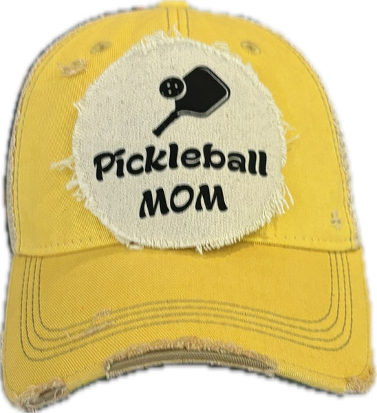 Pickleball Mom hat by BohoGroove featuring black Pickleball Mom lettering and black pickleball paddle graphic on a yellow vintage distressed snapback hat