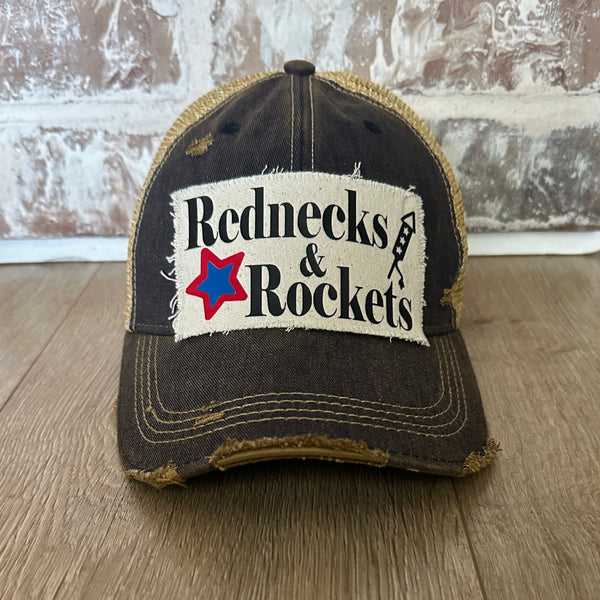 Rednecks And Rockets hat by BohoGroove with black lettering, red and blue star graphic, and firework rocket graphic on distressed off-white patch on navy vintage distressed snapback.