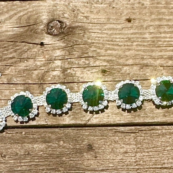 Rhinestone hat chain by BohoGroove, Emerald City, showing faceted emerald green rhinestones surrounded by sparkling clear rhinestone details on a silver tone chain.