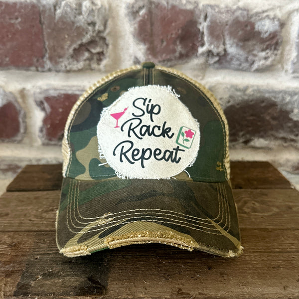Sip, Rack, Repeat Mahjong hat by BohoGroove featuring black Sip, Rack, Repeat lettering with Mahjong tile graphic and a pink martini glass on an off-white distressed patch on a camo vintage distressed snapback trucker hat.