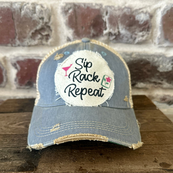 Sip, Rack, Repeat Mahjong hat by BohoGroove featuring black Sip, Rack, Repeat lettering with Mahjong tile graphic and a pink martini glass on an off-white distressed patch on a light blue vintage distressed snapback trucker hat.