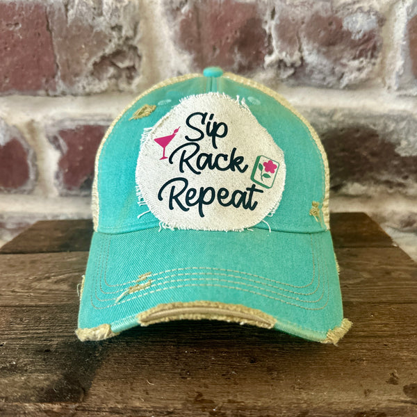 Sip, Rack, Repeat Mahjong hat by BohoGroove featuring black Sip, Rack, Repeat lettering with Mahjong tile graphic and a pink martini glass on an off-white distressed patch on an ocean blue vintage distressed snapback trucker hat.