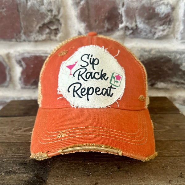 Sip, Rack, Repeat Mahjong hat by BohoGroove featuring black Sip, Rack, Repeat lettering with Mahjong tile graphic and a pink martini glass on an off-white distressed patch on an orange vintage distressed snapback trucker hat.