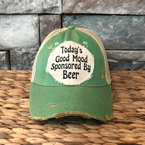 Green cap with a humorous text design on a stone surface