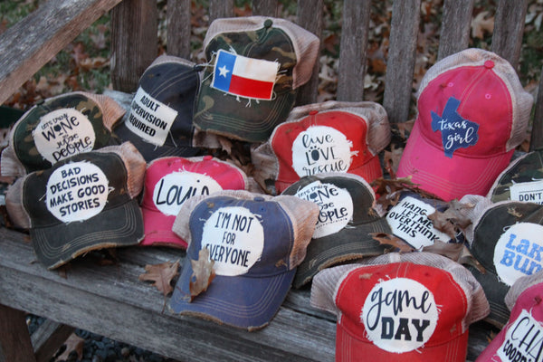 A bunch of BohoGroove hats sitting on a bench.
