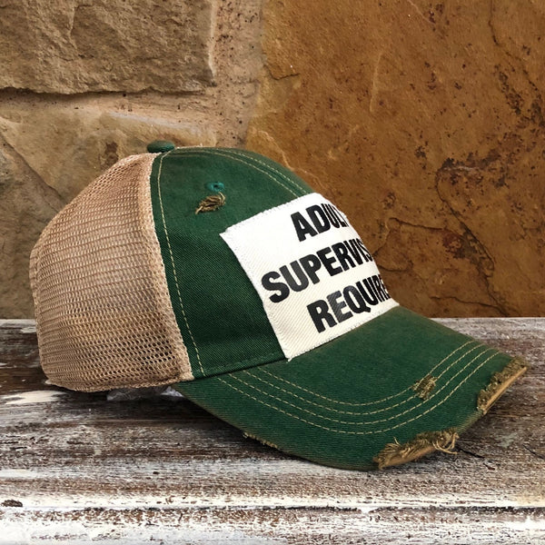 Adult Supervision Required hat by BohoGroove with black lettering on a distressed off-white patch on a green vintage distressed snapback trucker hat.