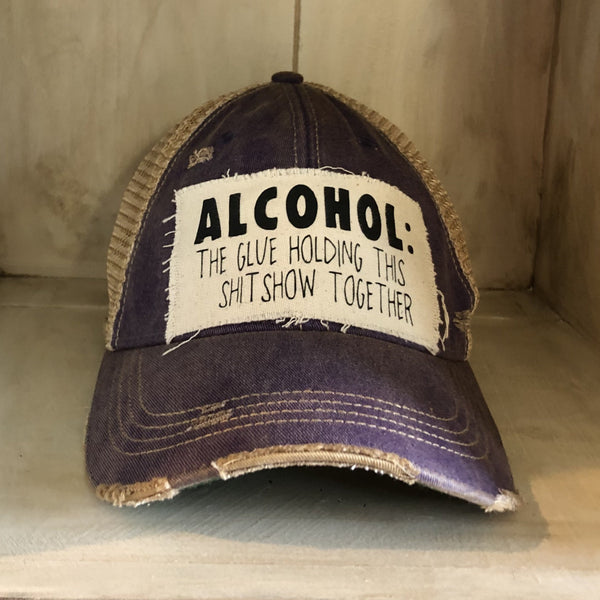 Alcohol: The Glue Holding This Shitshow Together hat by BohoGroove with black lettering on a distressed off-white patch on a purple vintage distressed snapback trucker hat.
