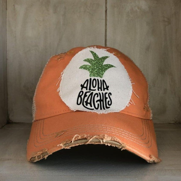 Aloha Beaches hat by BohoGroove with black Aloha Beaches lettering and green pineapple graphic on distressed off-white patch and sherbet vintage distressed snapback.
