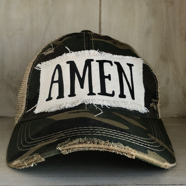 Amen hat by BohoGroove with black Amen lettering on distressed off-white patch on a camo vintage distressed snapback.