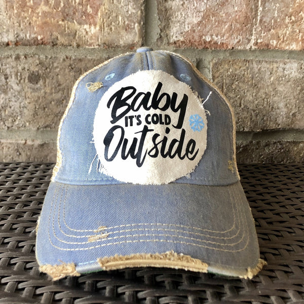 Baby It's Cold Outside hat by BohoGroove with black script lettering and a blue snowflake graphic on a distressed off-white custom patch on a light blue vintage distressed snapback.