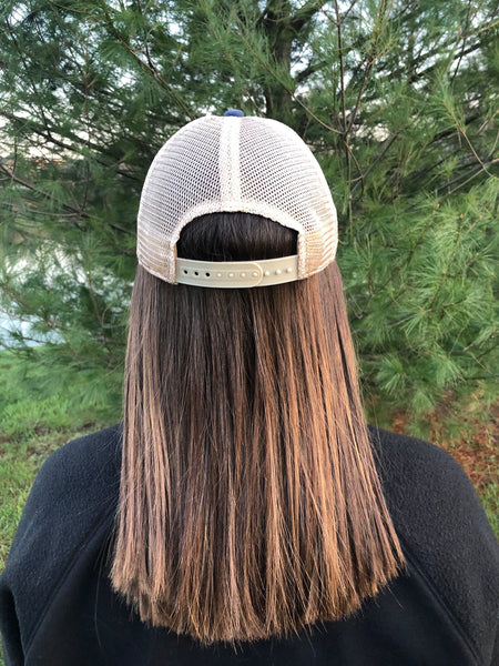 Back view of BohoGroove vintage distressed trucker hat with adjustable snapback closure and mesh back on model.