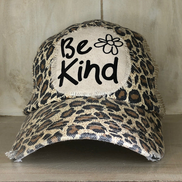 Be Kind hat by BohoGroove with black Be Kind lettering and flower graphic on distressed off-white patch on leopard vintage distressed snapback.