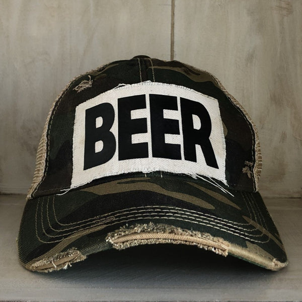 Beer hat by BohoGroove with black lettering on a distressed off-white custom patch on a camo vintage distressed snapback.