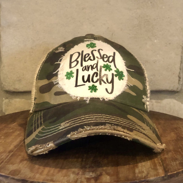 Blessed and Lucky hat by BohoGroove with green lettering and shamrock graphics on a distressed off-white custom patch on a camo vintage distressed snapback.