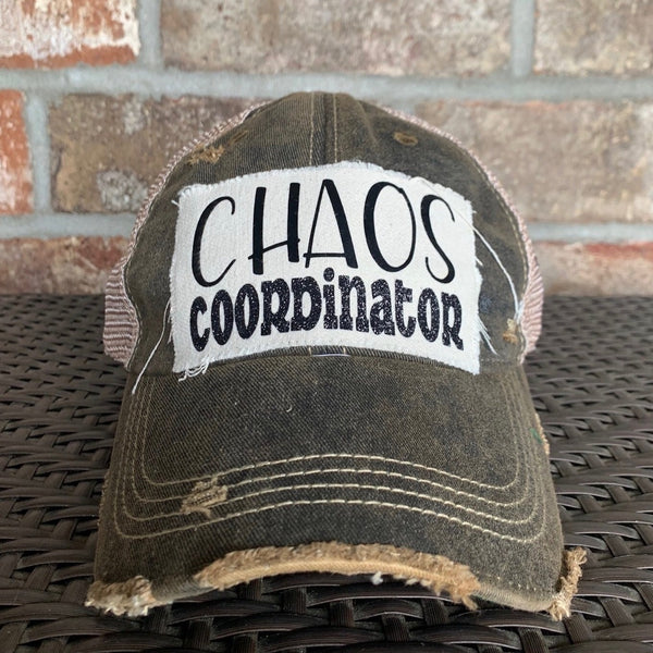 Chaos Coordinator hat by BohoGroove with black Chaos Coordinator lettering on a distressed off-white patch on a black vintage distressed snapback trucker hat.