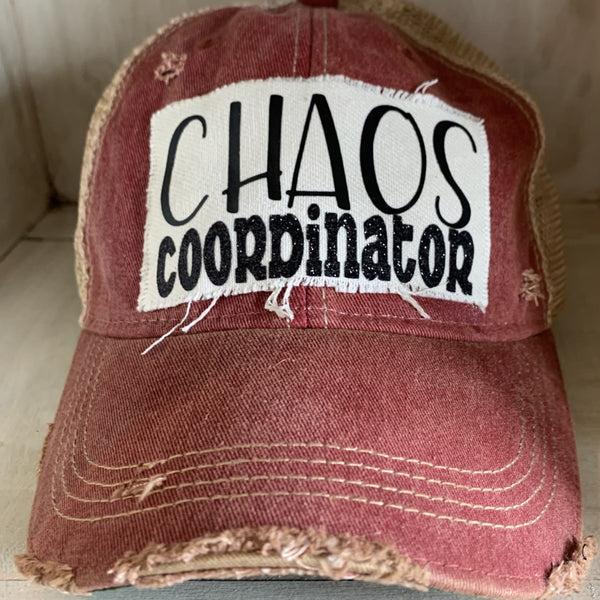 Chaos Coordinator hat by BohoGroove with black Chaos Coordinator lettering on a distressed off-white patch on a brick red vintage distressed snapback trucker hat.