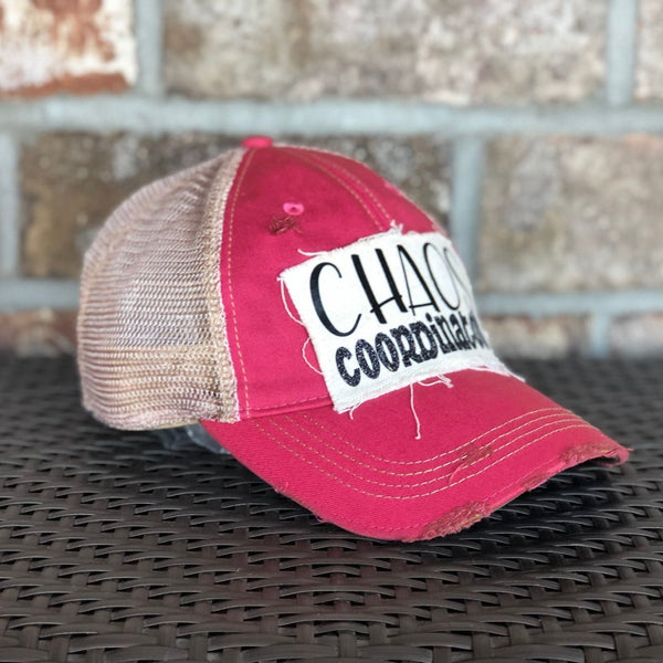Left side view of Chaos Coordinator hat by BohoGroove with black Chaos Coordinator lettering on a distressed off-white patch on a pink vintage distressed snapback trucker hat.