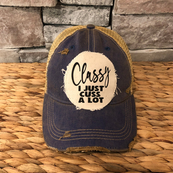 Classy, I Just Cuss a Lot hat by BohoGroove with black lettering on a distressed off-white patch on a navy blue vintage distressed snapback trucker hat.