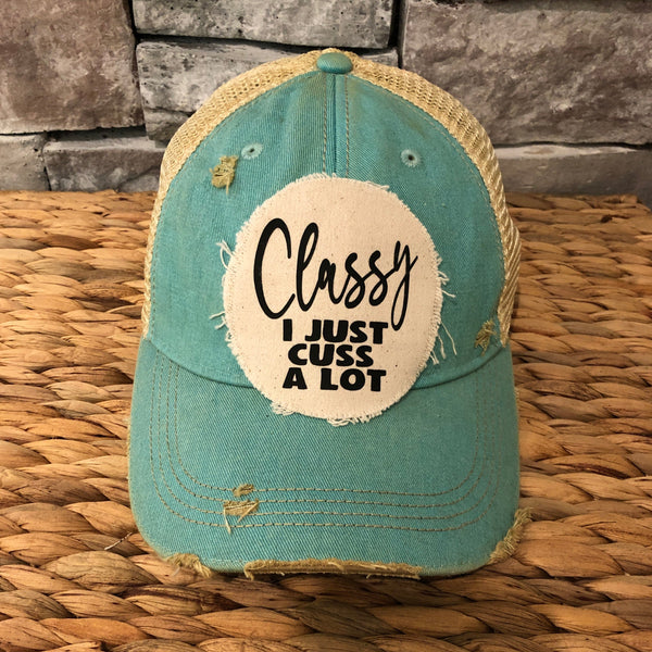 Classy, I Just Cuss a Lot hat by BohoGroove with black lettering on a distressed off-white patch on an ocean blue vintage distressed snapback trucker hat.