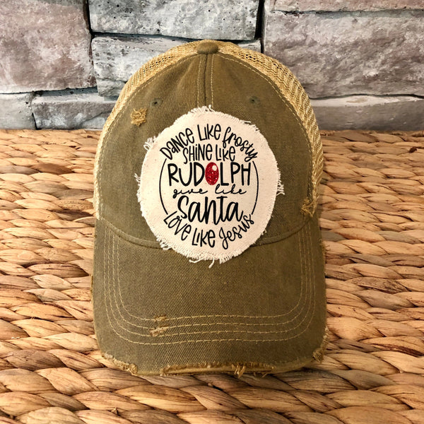 Dance Like Frosty Shine Like Rudolph Give Like Santa Love Like Jesus hat by BohoGroove with red and green lettering and Christmas phrase on a distressed off-white patch on an olive vintage distressed snapback.