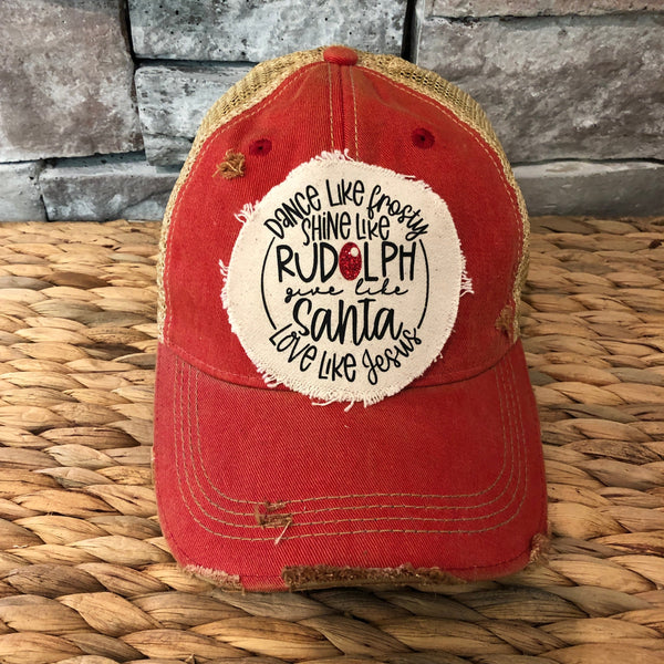 Dance Like Frosty Shine Like Rudolph Give Like Santa Love Like Jesus hat by BohoGroove with red and green lettering and Christmas phrase on a distressed off-white patch on a red vintage distressed snapback.