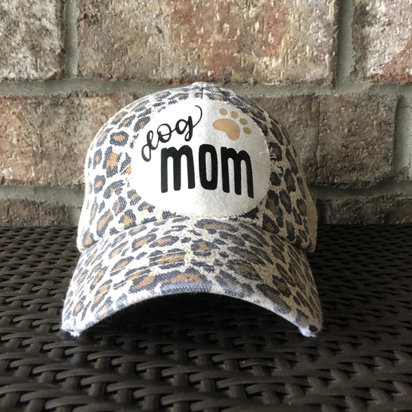Dog Mom hat by BohoGroove featuring black Dog Mom lettering and tan paw print graphic on a leopard vintage distressed snapback hat