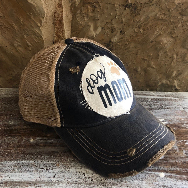 Dog Mom hat by BohoGroove featuring black Dog Mom lettering and tan paw print graphic on a navy blue vintage distressed snapback hat right side 
