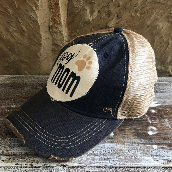Dog Mom hat by BohoGroove featuring black Dog Mom lettering and tan paw print graphic on a navy blue vintage distressed snapback hat right side 