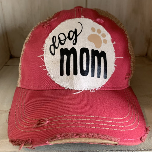 Dog Mom hat by BohoGroove featuring black Dog Mom lettering and tan paw print graphic on a pink vintage distressed snapback hat