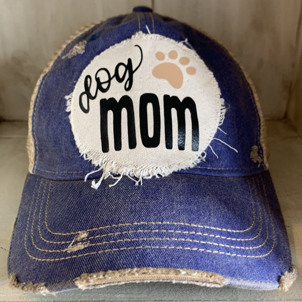 Dog Mom hat by BohoGroove featuring black Dog Mom lettering and tan paw print graphic on a royal blue vintage distressed snapback hat