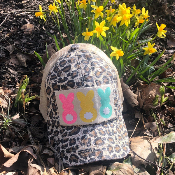 Easter Bunny hat by BohoGroove with pink, yellow, and mint bunny graphics with white flower accents on distressed off-white patch on a leopard vintage distressed snapback.