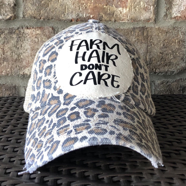Farm Hair Don't Care hat by BohoGroove with black Farm Hair Don't Care lettering on a distressed off-white patch on a leopard vintage distressed snapback.