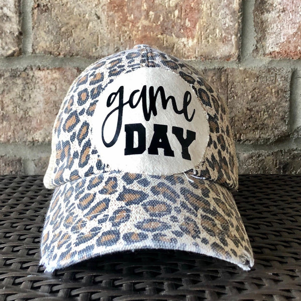 Game Day sports hat by BohoGroove with black Game Day lettering on distressed off-white patch on leopard vintage distressed snapback.