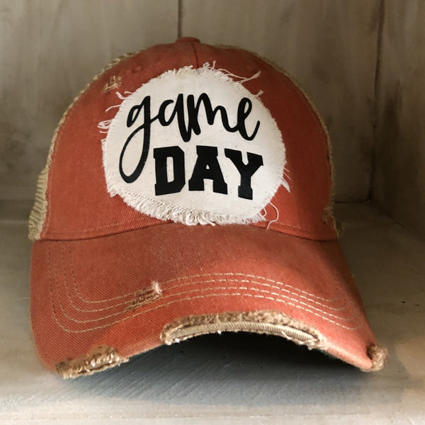 Game Day sports hat by BohoGroove with black Game Day lettering on distressed off-white patch on an orange vintage distressed snapback.