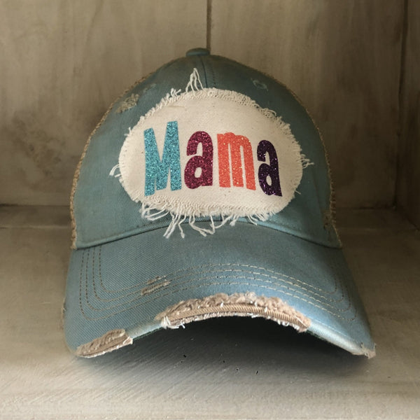 Mama Hat by BohoGroove with turquoise, pink, orange, and purple glitter Mama lettering on distressed off-white patch on an ocean blue vintage distressed snapback