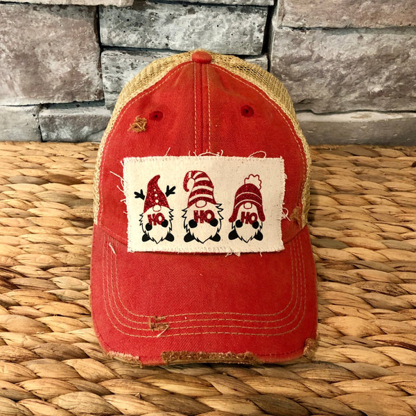 Gnome Ho Ho Ho hat by BohoGroove with three Christmas gnomes wearing red glitter hats and Ho Ho Ho lettering on a distressed off-white patch on a red vintage distressed snapback.