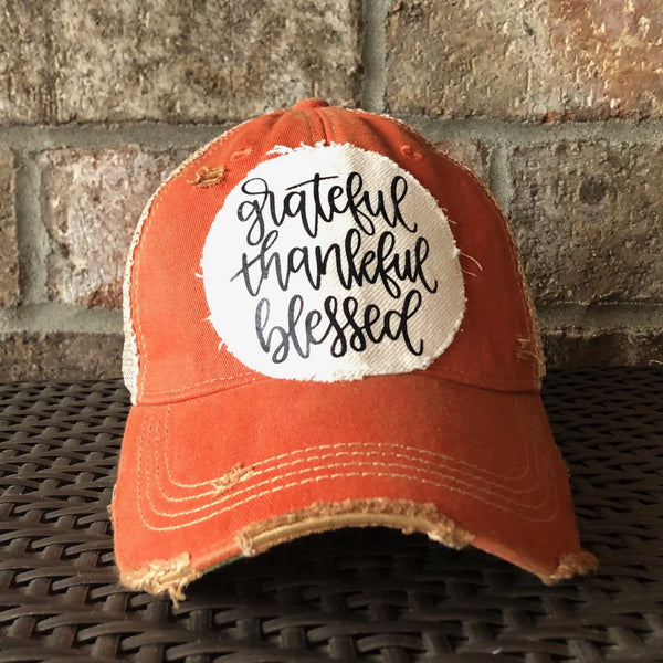 Grateful Thankful Blessed hat by BohoGroove with black grateful thankful blessed script lettering on a cream patch on an orange vintage distressed snapback.