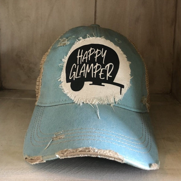 Happy Glamper hat by BohoGroove with black Happy Glamper camper graphic on a distressed off-white patch on an ocean blue vintage distressed snapback trucker hat.