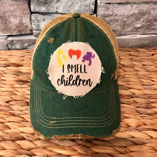 Hocus Pocus Glitter I Smell Children hat by BohoGroove with yellow, orange and purple glitter witch silhouettes and I Smell Children wording on a distressed off-white patch on a green vintage distressed snapback.