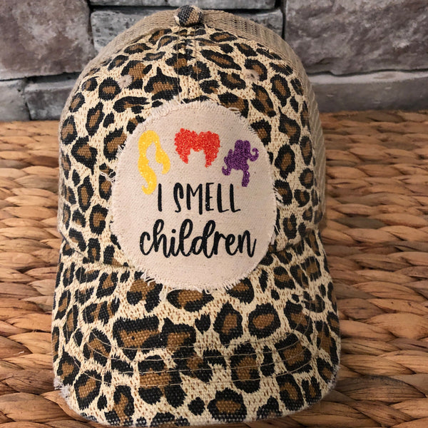 Hocus Pocus Glitter I Smell Children hat by BohoGroove with yellow, orange and purple glitter witch silhouettes and I Smell Children wording on a distressed off-white patch on a leopard vintage distressed snapback.