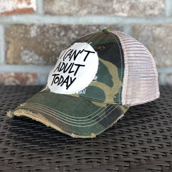 Right side view of I Can't Adult Today hat by BohoGroove with black lettering on a distressed off-white patch on a camo vintage distressed snapback trucker hat.