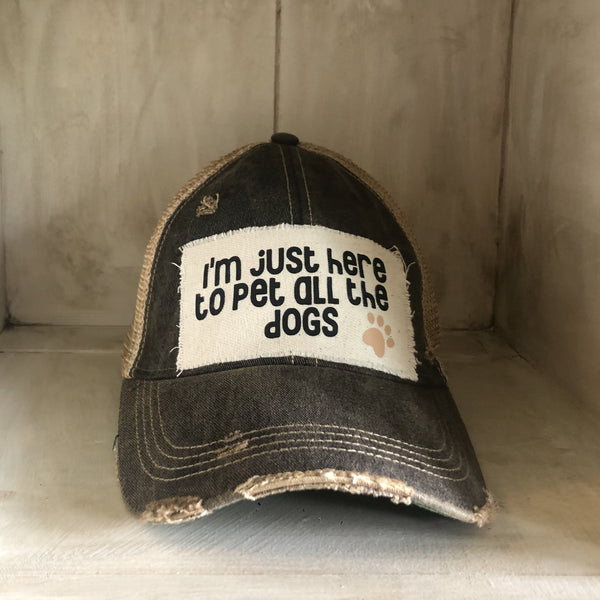 I'm Just Here to Pet All the Dogs hat by BohoGroove with black I'm Just Here to Pet All the Dogs lettering and paw print graphic on a distressed off-white patch on a black vintage distressed snapback.