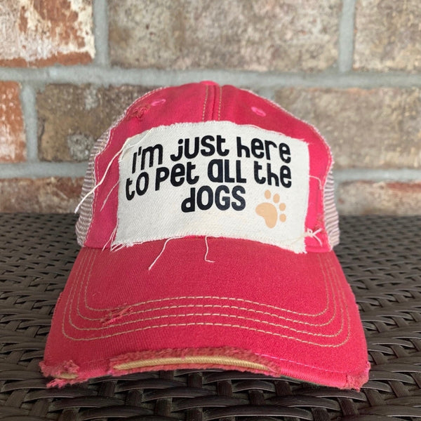 I'm Just Here to Pet All the Dogs hat by BohoGroove with black I'm Just Here to Pet All the Dogs lettering and paw print graphic on a distressed off-white patch on a pink vintage distressed snapback.