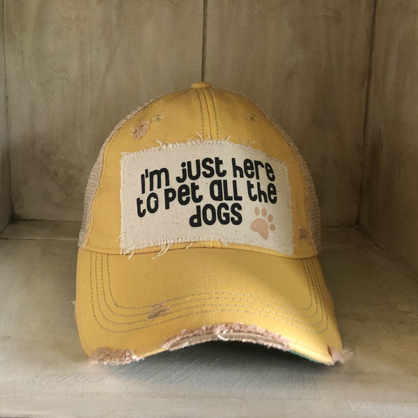 I'm Just Here to Pet All the Dogs hat by BohoGroove with black I'm Just Here to Pet All the Dogs lettering and paw print graphic on a distressed off-white patch on a yellow vintage distressed snapback.