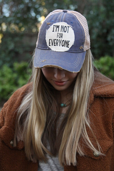 Model wearing BohoGroove Im Not For Everyone hat featuring black lettering on a distressed off-white patch on a blue vintage distressed snapback.
